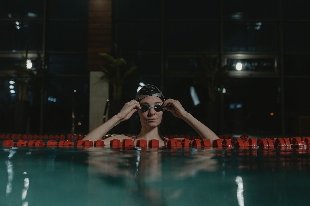Lunettes de natation posées sur le rebord du bassin